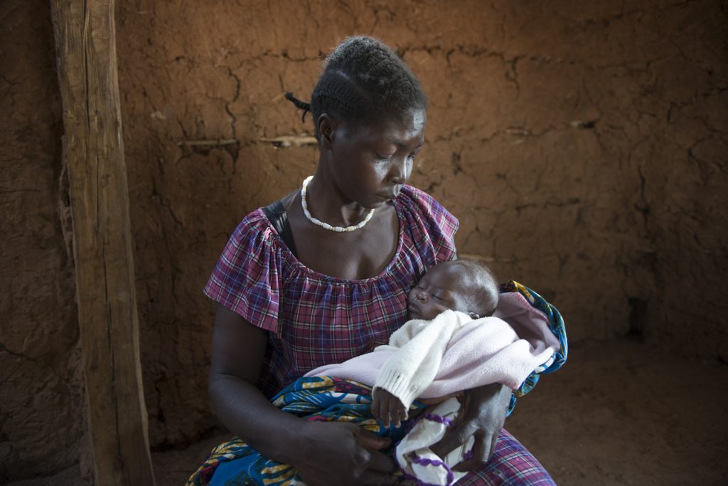 Faustina Joseph with her five month baby, born in South Sudan. The baby is sick and she has no money to go to the hospital. Philip, her husband, died in an attack 'They came to our house and ask for money - I was at the neighbour’s place. When he tried to escape, he was shot right at the door, pushed inside and the door locked after him and he was burned with the house'.