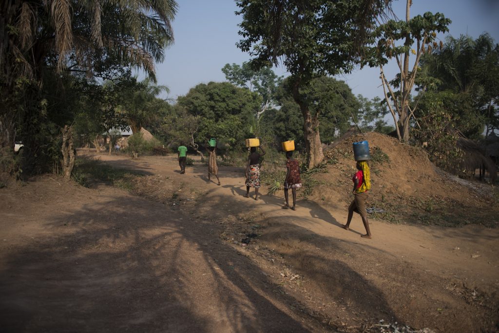 Victoria, 16, Justine, 14, Jacinta, 14, Tamelego, 7, Hellen, 6 and Emmanuel 16 a family of refugees from South Sudan who fled here to Dungu in Soith Sudan, fetch water from the well near the home of the Congolese family that has taken them in.