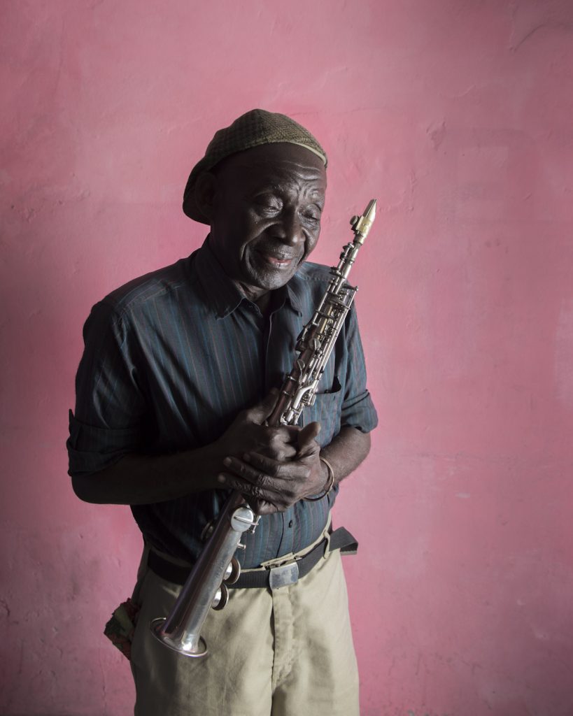 Paul Mayena, saxophoniste de jazz, né en 1938. Il se forme à la fanfare Saint-Antoine de Kolwezi. Son père lui donnera le goût de la musique en lui passant des disques de Charlie Parker et Duke Ellington. Arrivé à Lubumbashi, il forme son premier groupe : Banka Jazz. Lors d’un concert à Kinshasa avec Pongo Love, grande voix de la rumba congolaise, il rencontre Mobutu. Il recevra son premier saxophone du Maréchal quelques années plus tard. Il quitte le Zaïre en 1981 pour des raisons économiques et part s’installer à Pointe-Noire, où il créé un nouveau groupe. Il fera ensuite de nombreuses tournées européennes avec le groupe Super Boboto de Brazza. En 2012, il retourne à Kinshasa, fuyant la guerre civile qui ravage le Congo Brazzaville.