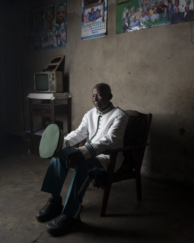 Kinshasa, République démocratique du Congo. Masamba Toukala Kiese, menuisier charpentier et membre de la fanfare Kibanguiste. Né en 1931 à Mbanza Ngungu, il s’installe à Léopoldville en 1963 ; la ville est en plein boum démographique et a besoin de main d’œuvre. En 1983, Mobutu l’envoie à Mbandaka, avec une centaine d’ouvriers pour construire un palais dans la capitale de sa province natale. Masamba y restera huit mois. Le jour de l’inauguration, le président lui remit une médaille du mérite. « Mobutu était un homme bon et mauvais à la fois : si il appréciait ton travaille, il te couvrait d’argent. Mais dès que tu lui déplaisais, cela tournait très mal ».Interview réalisée le 15/11/2015Portrait posé à son domicile.