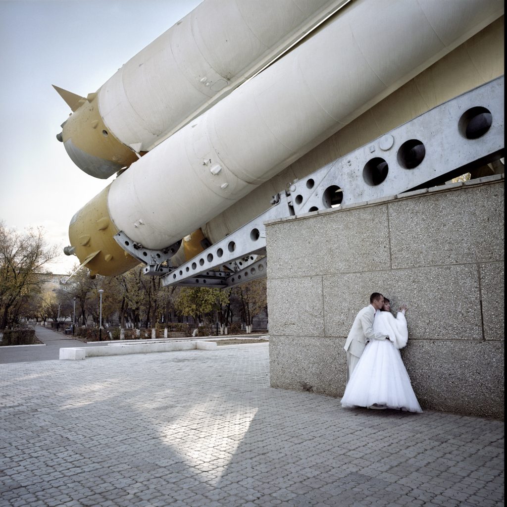 Russian newlyweds are taken in picture in the shadow of a rocket, Baikonur town.