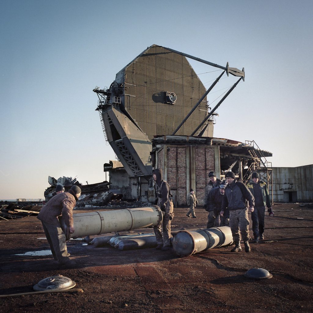 Kazakhs dismanteling the military antena of object n°38 for scrap metal.